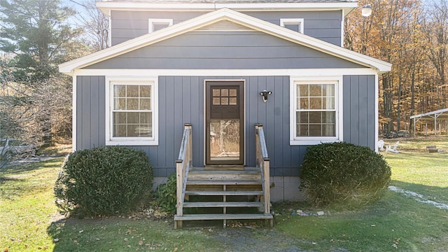 doorway to property with a lawn