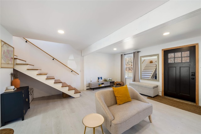 foyer entrance with baseboard heating and wood-type flooring