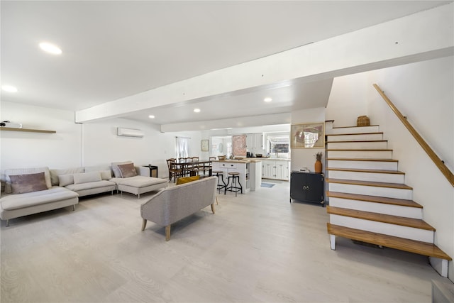 living room featuring light wood-type flooring and a wall mounted AC