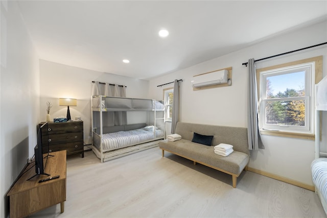 bedroom with a wall mounted air conditioner and hardwood / wood-style floors