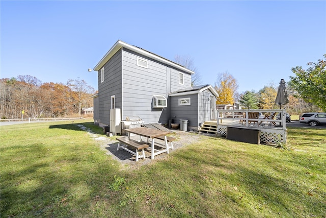 rear view of property featuring a lawn and a deck