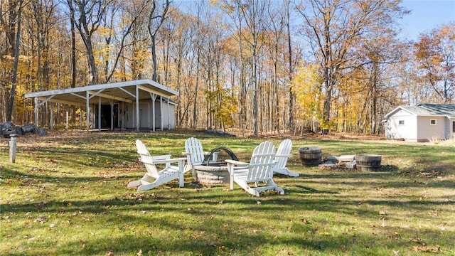 view of yard featuring an outdoor structure and an outdoor fire pit