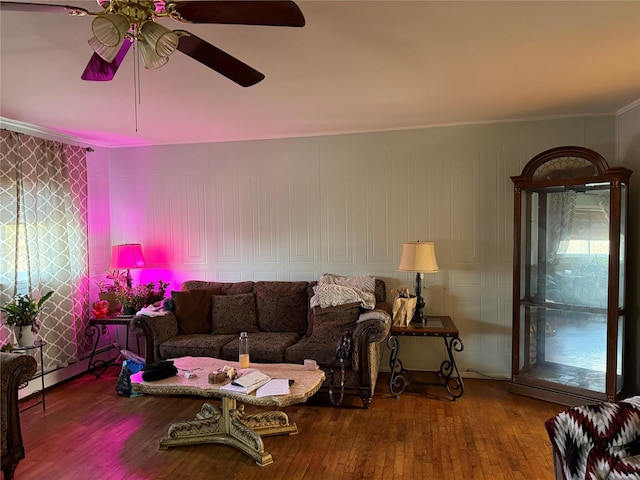 living room featuring hardwood / wood-style flooring, crown molding, ceiling fan, and a baseboard heating unit