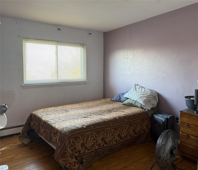 bedroom with hardwood / wood-style floors and a baseboard radiator