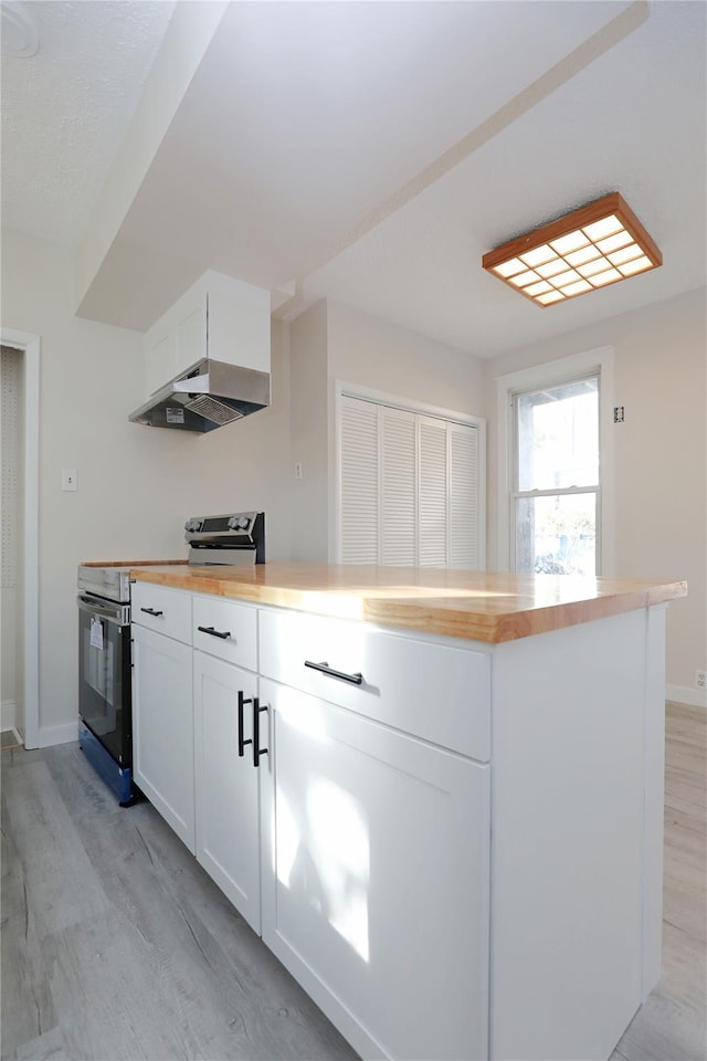 kitchen featuring stainless steel range with electric stovetop, under cabinet range hood, white cabinetry, light wood-style floors, and wooden counters