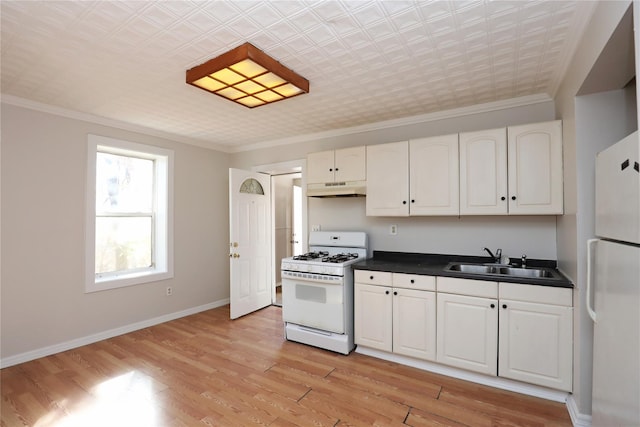 kitchen featuring white appliances, ornamental molding, a sink, under cabinet range hood, and dark countertops