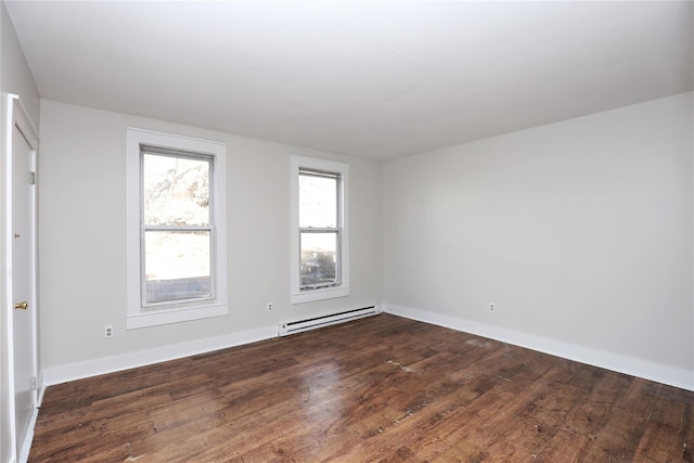 spare room featuring dark wood-style floors, baseboards, and a baseboard radiator