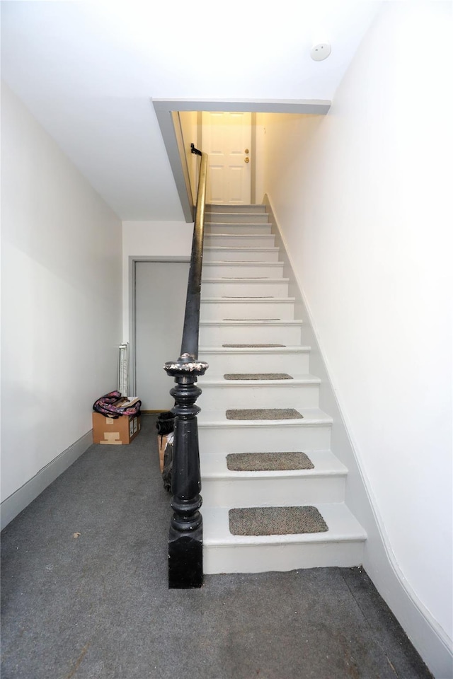 stairs featuring carpet flooring and baseboards