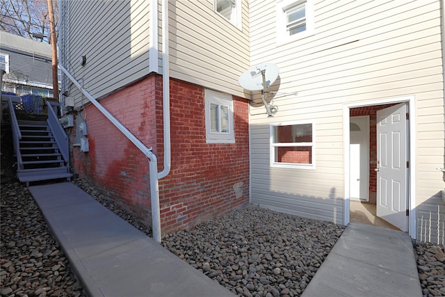 view of side of property featuring brick siding and stairs