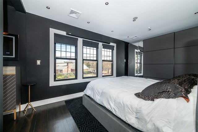 bedroom with dark hardwood / wood-style flooring