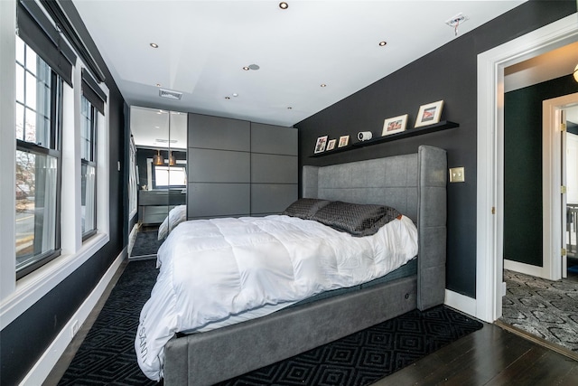 bedroom with lofted ceiling and dark wood-type flooring