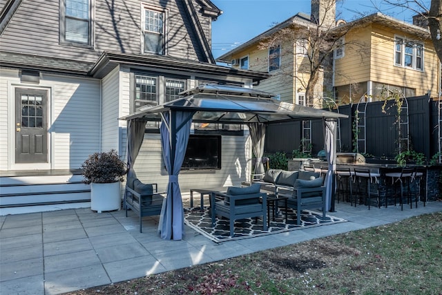 back of property featuring an outdoor living space, a patio, an outdoor bar, and a gazebo