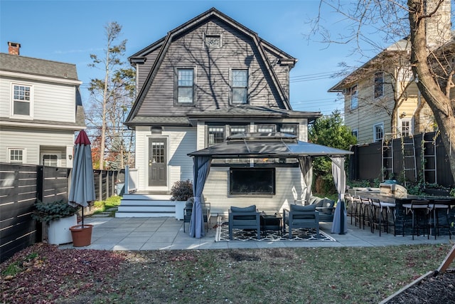 back of property featuring a gazebo, an outdoor bar, and a patio area