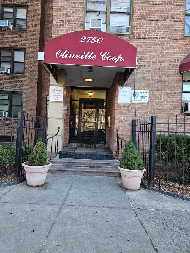 2750 Olinville Ave Unit 4H, Bronx, NY 10467 - doorway to property with brick siding and cooling unit