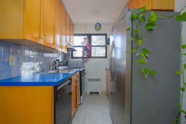 kitchen with backsplash, stainless steel appliances, radiator, and sink