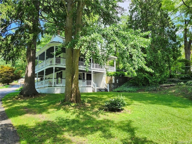 view of yard with covered porch and a balcony