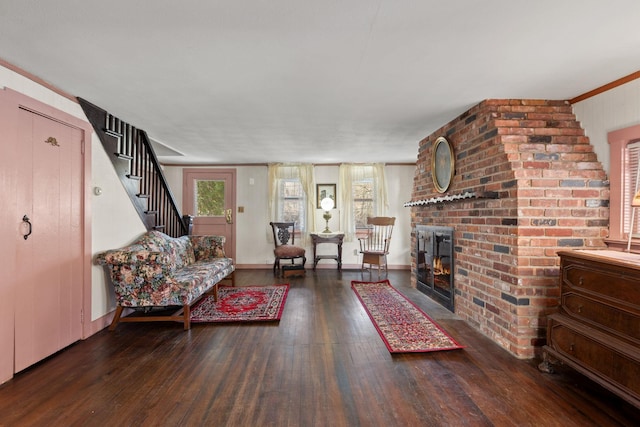 living room with crown molding, a fireplace, and dark hardwood / wood-style floors