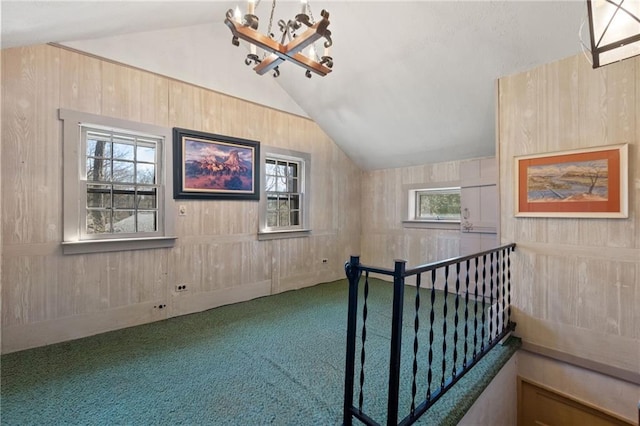 additional living space featuring plenty of natural light, carpet floors, a chandelier, and vaulted ceiling