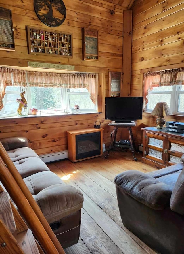 living room featuring wood walls, lofted ceiling, and light wood-type flooring