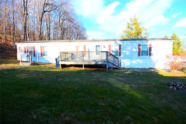 back of property with a yard and a wooden deck