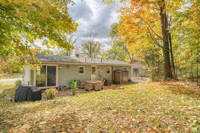 rear view of property featuring a shed