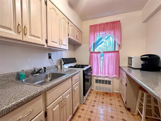 kitchen featuring light brown cabinets, radiator heating unit, sink, and range with gas cooktop