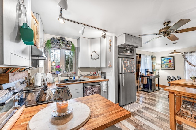 kitchen with white cabinetry, ceiling fan, sink, stainless steel appliances, and light hardwood / wood-style flooring