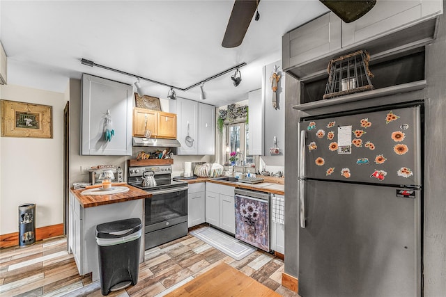 kitchen with wood counters, white cabinetry, light hardwood / wood-style floors, and appliances with stainless steel finishes