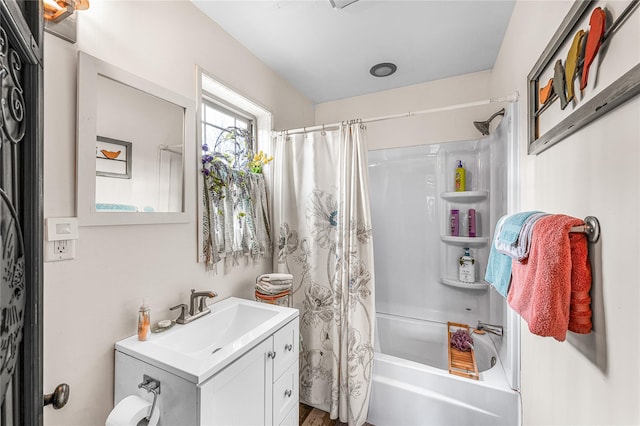 bathroom featuring shower / bath combo with shower curtain and vanity