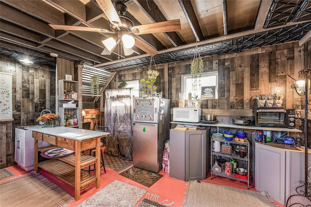 interior space featuring stainless steel refrigerator, wood walls, and sink