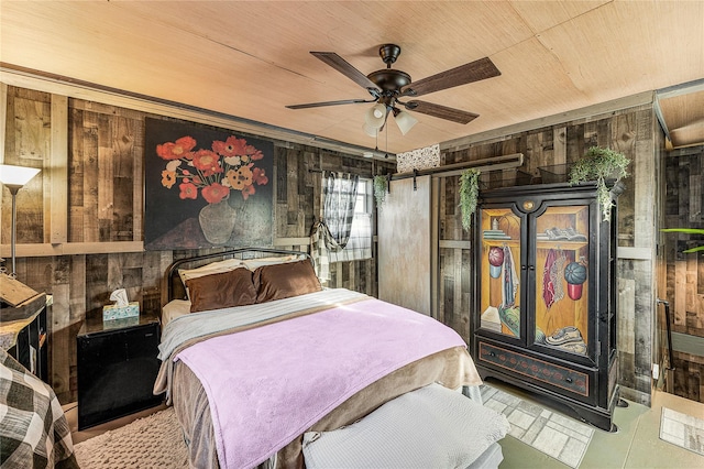 bedroom featuring a barn door, ceiling fan, wooden ceiling, and wood walls