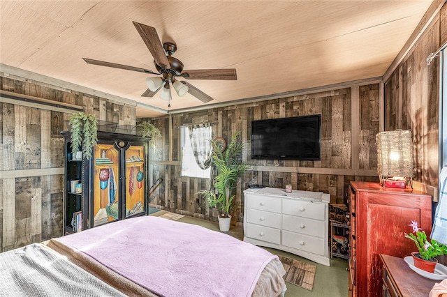 bedroom with ceiling fan and wood walls