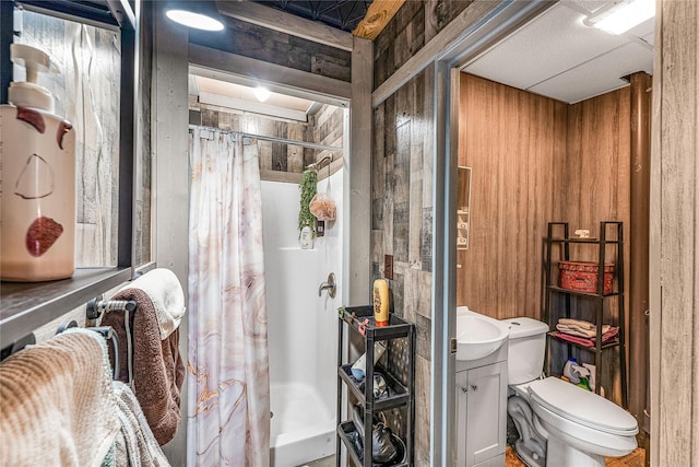 bathroom with vanity, curtained shower, toilet, and wooden walls