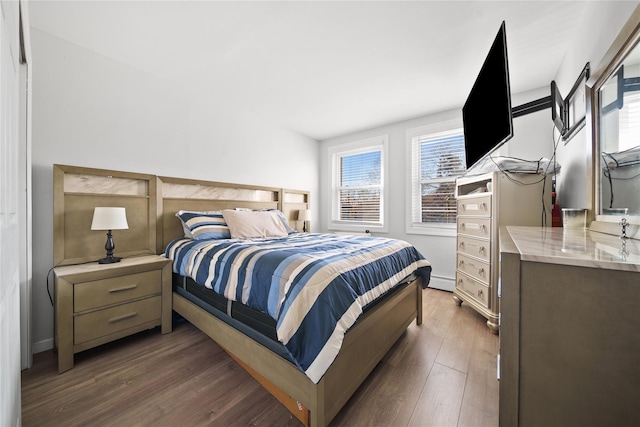 bedroom with dark hardwood / wood-style floors and a baseboard radiator