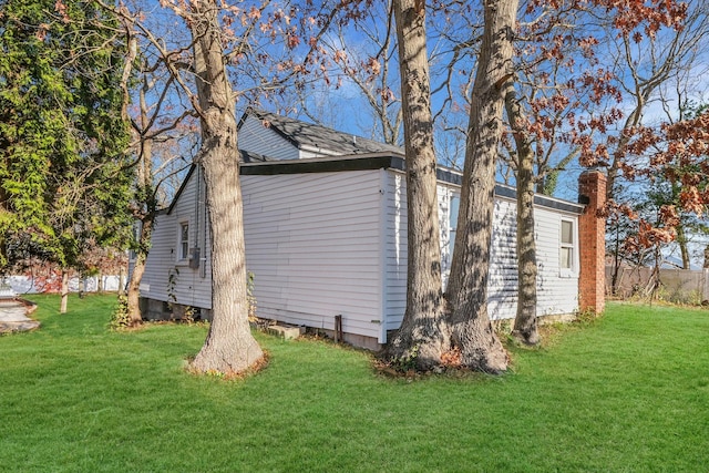 view of side of home with a yard