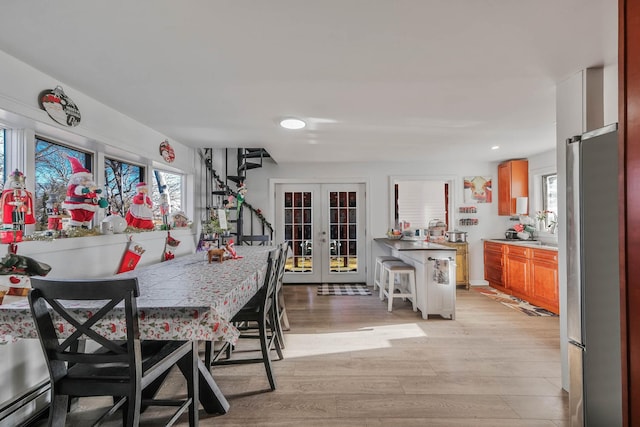 dining area with french doors and light hardwood / wood-style floors