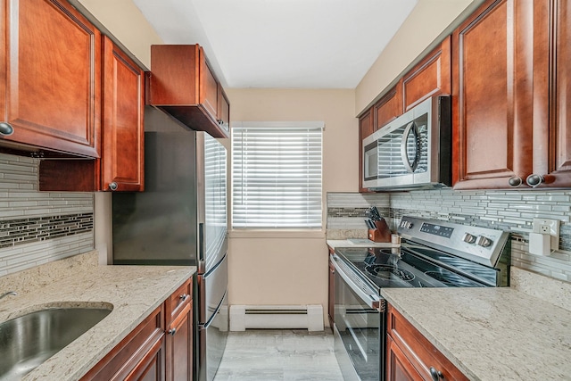 kitchen with appliances with stainless steel finishes, backsplash, light stone counters, sink, and a baseboard radiator