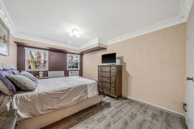 bedroom featuring crown molding and light hardwood / wood-style flooring