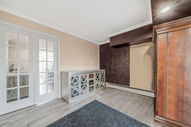 interior space with french doors, light wood-type flooring, crown molding, and a baseboard heating unit