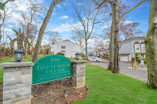 community sign featuring a lawn and a garage