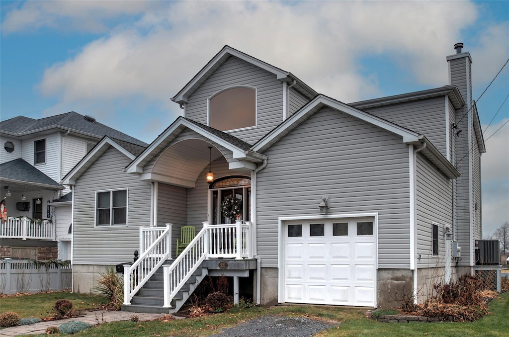 view of front of home with central AC unit and a garage