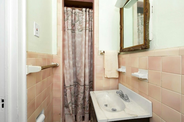 bathroom with vanity and tile walls