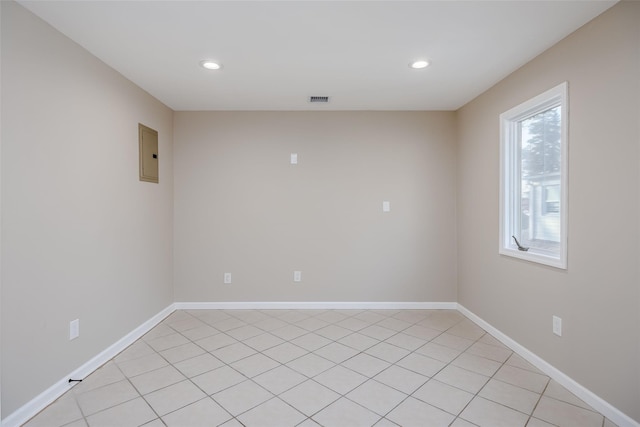 empty room featuring light tile patterned floors and electric panel