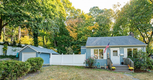 view of front of home with an outbuilding, a garage, and a front lawn