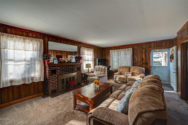 living room featuring wood walls, a fireplace, carpet, and ornamental molding