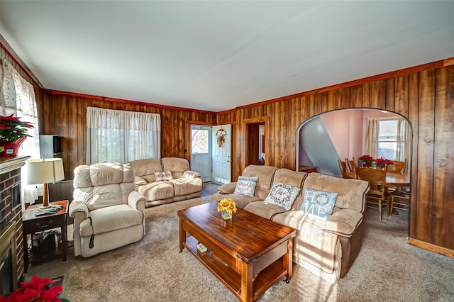 living room with a wealth of natural light, wooden walls, and crown molding