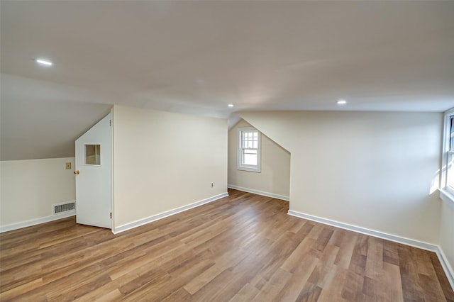 bonus room with light hardwood / wood-style flooring and lofted ceiling