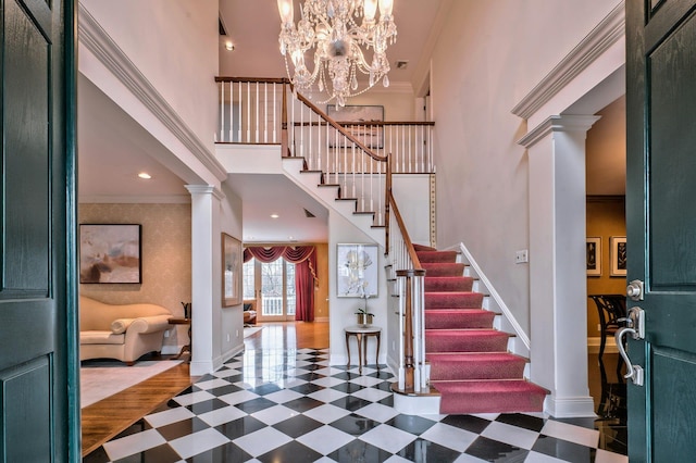 entryway featuring decorative columns, crown molding, a chandelier, and dark hardwood / wood-style floors