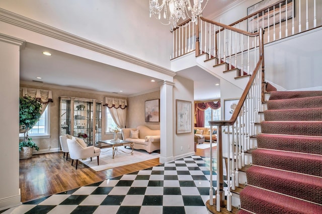 interior space featuring hardwood / wood-style floors, decorative columns, ornamental molding, and a notable chandelier