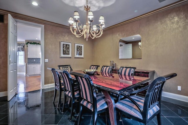 dining room featuring dark tile patterned flooring, ornamental molding, and a chandelier